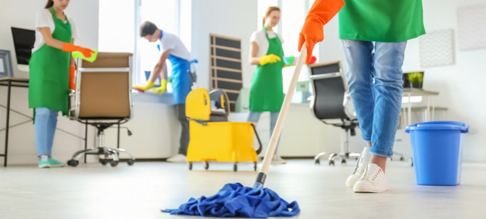 A diverse group of individuals collaboratively cleaning and organizing a room, showcasing teamwork and diligence.