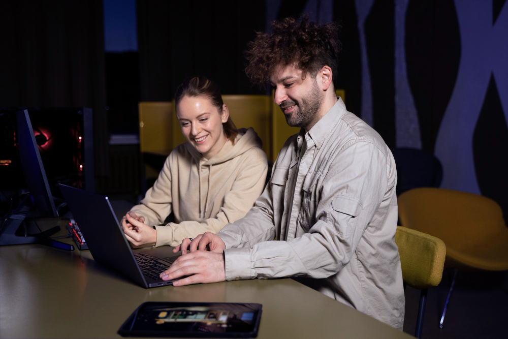 A man and woman collaborate at a table with a laptop, experiencing the innovative streaming capabilities of Superbox Elite Ultra.