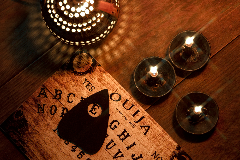 A table adorned with candles and an ouija board, symbolizing psychic readings for navigating life's challenges.