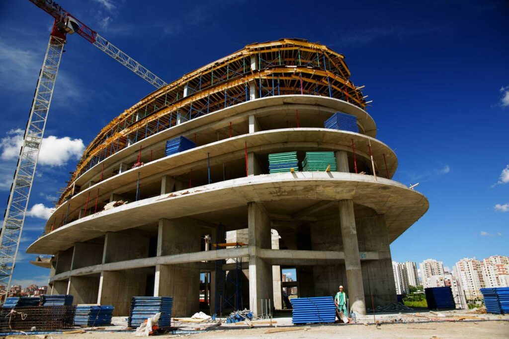 "Modern warehouse under construction with concrete structure and scaffolding, showcasing professional warehouse building solutions by a trusted warehouse construction company offering expert construction services."
