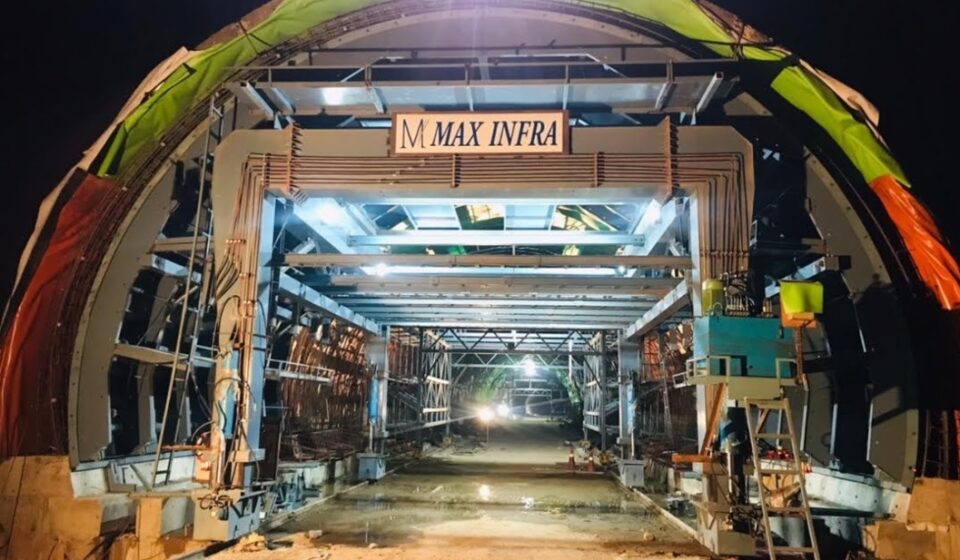 Tunnel construction work for railway infrastructure project with waterproofing system and structural support framework at night