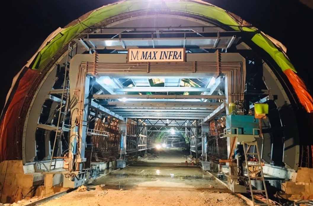 Tunnel construction work for railway infrastructure project with waterproofing system and structural support framework at night